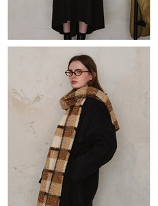 Detailed texture of thick plaid scarf in earthy brown tones with cozy knit finish