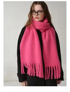 Close-up of bright pink wool blend scarf with fringe tassels and soft mohair texture