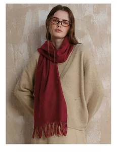 Close-up of dark red wool scarf with fringe tassels and soft cashmere texture