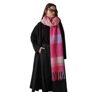 Pink and purple plaid winter scarf with thick tassels for women shown on a model