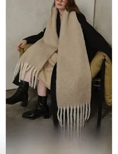 Close-up of oatmeal wool scarf featuring brushed texture and thick twisted tassels