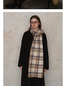 Detailed view of the plaid pattern and soft wool-like texture on this thick winter scarf