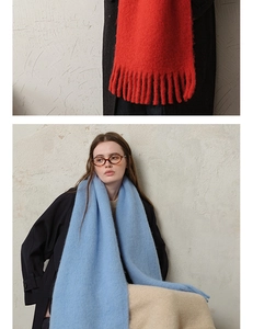 Detailed view of thick wool blend fringed scarves in solid red and light blue colors