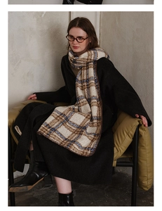 Close-up of thick plaid scarf texture with fine edge stitching and soft knit fabric