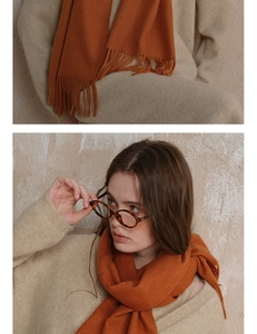 Close-up of warm orange wool scarf fabric texture and lifestyle styling with tassels