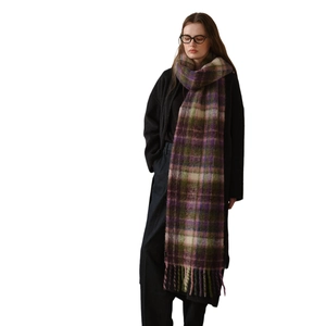 Thick plaid mohair scarf with tassels in purple and green worn with a black wool coat