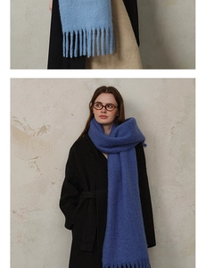 Close-up of soft wool blend scarf tassels in light blue and beige colors