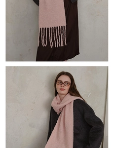 Detail of pink wool-blend bouclé knit scarf showing soft texture and tassel fringes