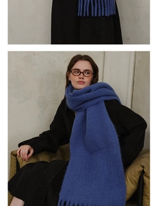 Detailed close-up showing the soft wool-blend texture and fringe of the Klein blue scarf