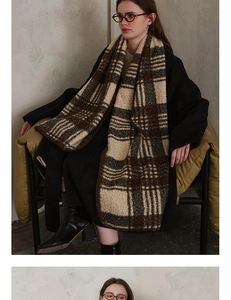 Detailed texture of thick plaid scarf featuring soft fleece-like beige and brown weaving
