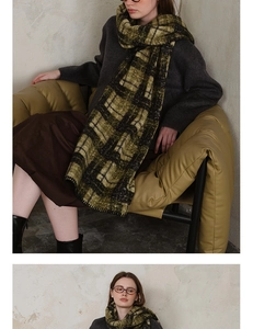 Detail of thick plaid knit scarf in dark green and black with soft lamb wool edges