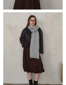 Detail of grey diamond-pattern knit scarf paired with a minimalist winter outfit