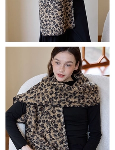 Detail of leopard print scarf featuring black stitched edges and thick knit texture