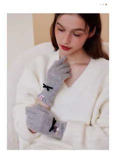 Detail of grey wool gloves with black bow, colorful buttons and touch screen finger