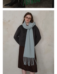 Detail view of mint green wool knit scarf with soft fringe edges and chunky texture