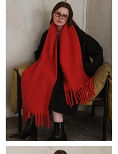 Close-up of bright red wool blend scarf with thick tassels and warm fuzzy texture