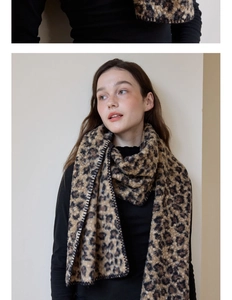 Detail of wool-like leopard print scarf showing plush texture and black stitching edge