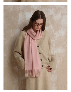 Close-up of pink wool tassel scarf paired with soft beige knitwear for autumn style