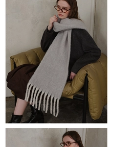 Close-up of light grey wool scarf showing soft fuzzy texture and thick tassel details
