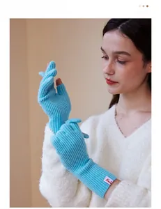 Detail of light blue wool blend gloves showing ribbed knit texture and branded cuff tag