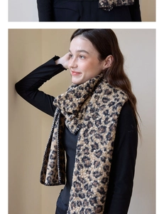 Close-up of leopard print scarf with black piping detail shown on a model