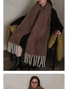 Detail of soft brown wool scarf featuring cream-colored thick tassels and fuzzy texture
