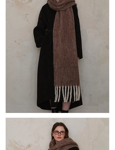 Detail of coffee brown wool scarf featuring thick knit texture and cream white fringe