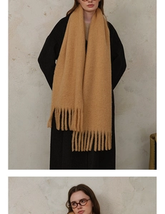 Detailed view of thick ginger wool blend scarf featuring elegant long tassels and soft texture