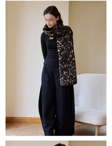 Fashionable leopard print wool scarf styled with black outfit in cozy minimalist interior