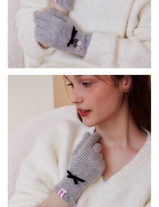 Detail of gray knit gloves with black velvet bow and decorative color buttons for women