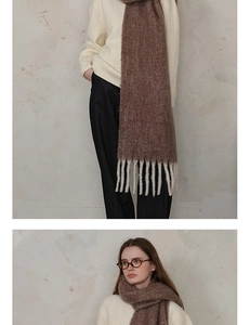 Detailed texture of thick brown wool scarf with tassels paired with white knit sweater