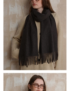 Detail of dark charcoal wool scarf featuring fine fringe and premium soft texture