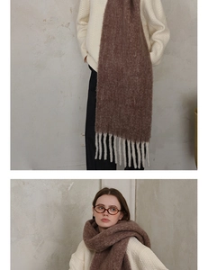 Detail of soft thick dark brown wool scarf with chunky white tassels for winter wear