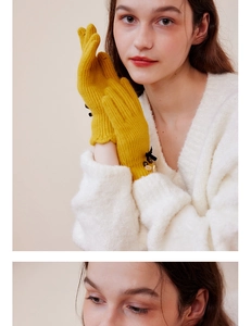 Close-up of yellow knit gloves with black bow and white buttons detail on the wrist