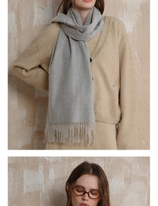 Close-up detail of grey wool scarf with fringe texture and soft premium fabric