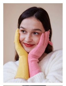 Detail of wool-blend knit gloves showing ribbed texture and pink-yellow contrast colors