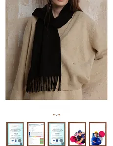 Detailed view of a soft black cashmere-feel wool scarf with classic fringe tassels