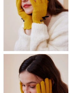 Detail of yellow knit wool gloves featuring black bow and colorful button accents