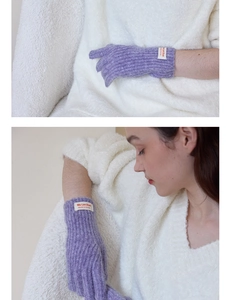 Detailed shot of purple knitted gloves featuring vertical ribbing and a sewn logo label