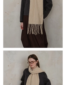 Detail of light beige wool-blend knit scarf showing textured fringe and soft material