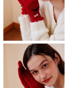 Detail of red knit gloves with bow, buttons and ruffled cuffs for elegant winter style