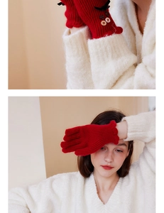 Detail of red wool knit gloves with black bow and double-row buttons on a white sweater