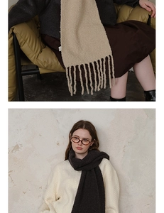 Detail view of thick wool blend knit scarf with long tassels in beige and grey colors