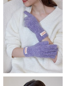 Detailed close-up of purple plush knit gloves featuring a stylish woven wrist label