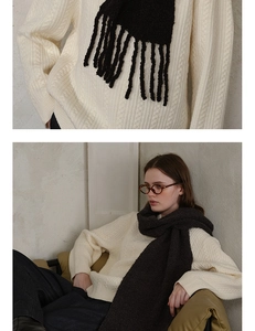 Detail of dark brown wool blend loop knit scarf with long tassels and chunky cable knit texture