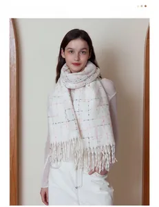 Close-up of white cashmere-like knit scarf with soft pink plaid texture and long tassels