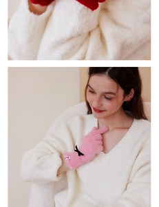 Detail of pink wool knit gloves featuring black ribbon bows and ribbed elastic cuffs