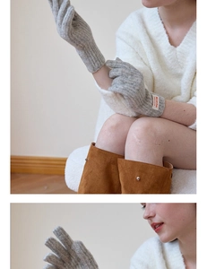 Close-up of grey plush knit gloves with touch screen tips and white brand label