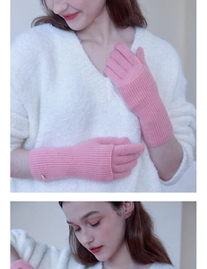 Detailed knit texture of pink wool gloves featuring ribbed cuffs and a gold charm