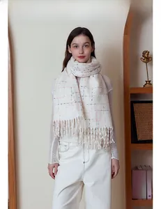 Close-up of cream plaid scarf with long tassels and soft cashmere-like texture